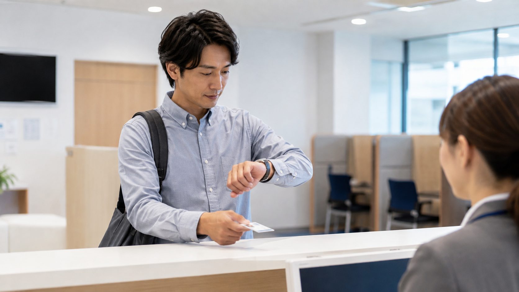 基本情報技術者試験の受付で到着時刻を確認する受験者