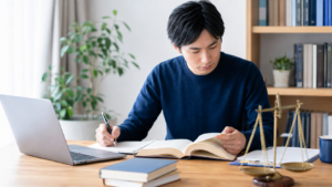 基本情報の取適法を学ぶ受験者と法律資料